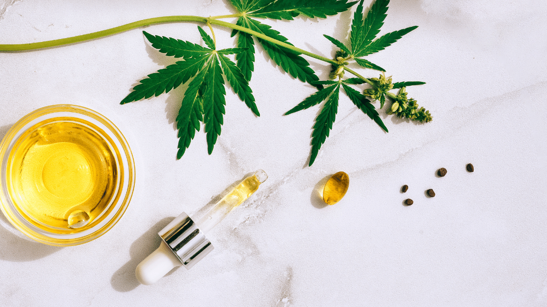 Image of oils in a dropper near a hemp leaf