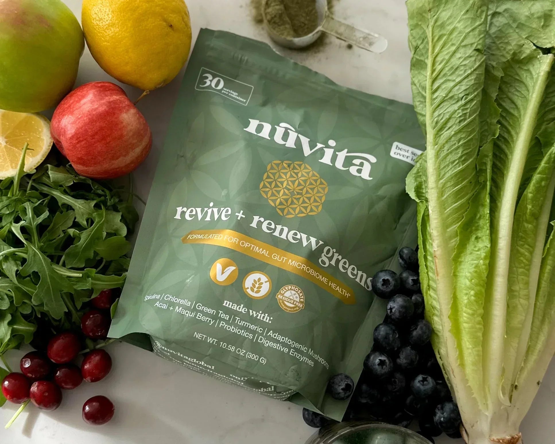 Nuvita Revive & Renew Greens with CBG Pouch laying on a table surrounded by various fruits and vegetables
