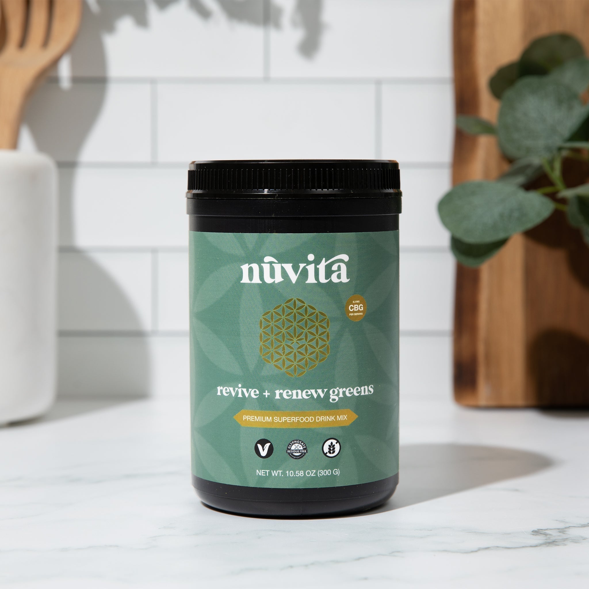 Canister of nuvita's original package of greens supplement sitting on a counter top in a kitchen